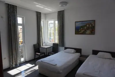 a hotel room with two beds and a window at SeaSide Guest Rooms in Burgas City