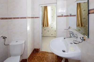 a bathroom with a toilet and a sink and a shower at Hotel Yantra in Sunny Beach