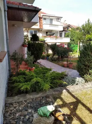 a garden in front of a house with a pile of rubbish at Guesthouse Kolevi in Lozenets