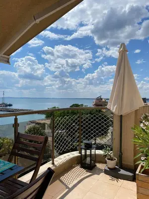 a patio with an umbrella and a view of the ocean at Apartment Nadejda in Pomorie