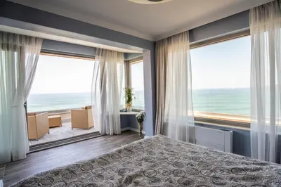 a bedroom with a bed and a view of the ocean at Villa Lili in Sozopol
