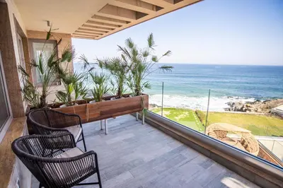 a balcony with chairs and a bench and the ocean at Villa Lili in Sozopol