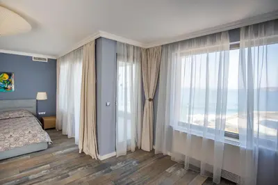 a bedroom with a bed and a large window at Villa Lili in Sozopol