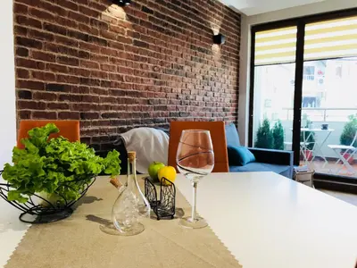 a table with a wine glass and plants on it at Bright, Comfortable and Cozy Apartment in Burgas City