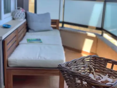 a couch and a bench on a balcony at Charming Beach Holiday Apartment in Lozenets