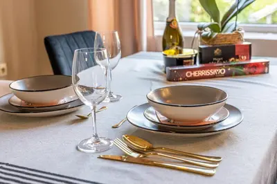 a table with two plates and glasses on it at City Center apartament “MARTA” in Varna City