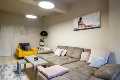 a living room with a couch and a yellow chair at City Center apartament “MARTA” in Varna City