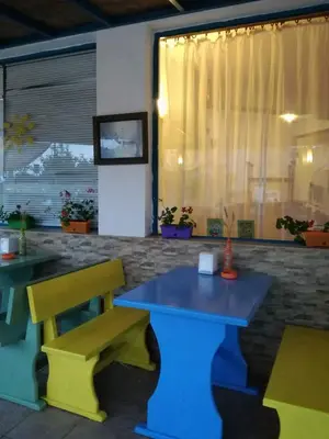 a colorful table and bench in a restaurant at Aura in Primorsko