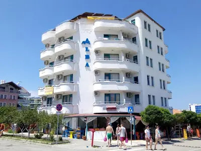a white building with a blue cross on it at Aura in Primorsko