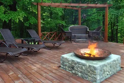 a fire pit on a wooden deck with chairs at Eco Complex Sherba in Debelets
