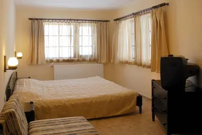 a bedroom with a bed and a tv and windows at Eco Complex Sherba in Debelets