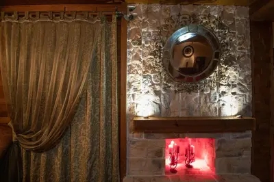 a mirror on a stone wall with candles in a room at Eco Complex Sherba in Debelets