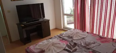 a living room with a flat screen tv and a couch at Sunny House in Byala