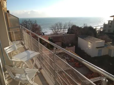 a balcony with a chair and a view of the ocean at Sunny House in Byala