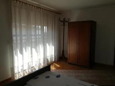 a bedroom with a bed and a window with curtains at Apartment Marchela in Nesebar