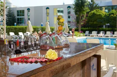 a counter with bottles of wine on it next to a pool at Karlovo Hotel in Sunny Beach