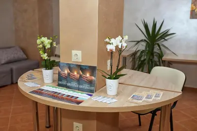 a wooden table with a book and flowers on it at Karlovo Hotel in Sunny Beach