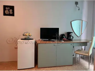 a desk with a television and a desk with a chair at Sozopol House Dimitrovi in Sozopol
