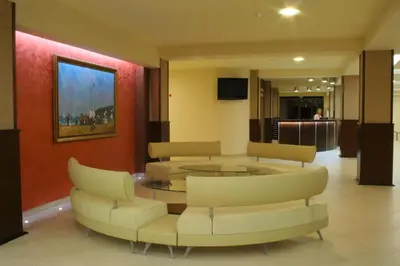 a waiting room with couches and a table and chairs at Hotel Iskar & Aquapark - All Inclusive in Sunny Beach