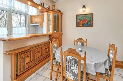 a dining room with a table and a kitchen at Апартамент Бриз in Burgas City