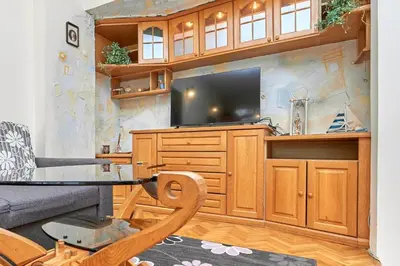 a living room with a tv and a couch and a table at Апартамент Бриз in Burgas City