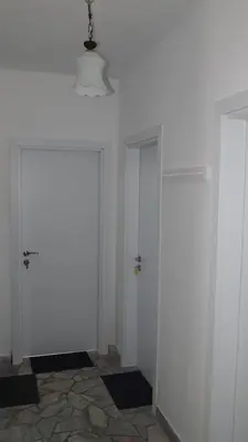 a hallway with two white doors and a tile floor at Villa Burkopolis in Sozopol
