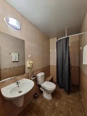 a bathroom with a white toilet and a sink at Hotel Elica in Varna City