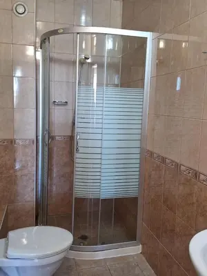 a bathroom with a shower with a toilet and a sink at Hotel Elica in Varna City