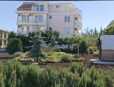 a large white building with a tree in a garden at Къща Веси VeSea in Nesebar