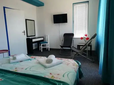 a bedroom with a bed and a desk and a chair at Къща Веси VeSea in Nesebar