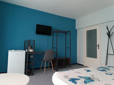 a bedroom with a blue wall with a bed and a desk at Къща Веси VeSea in Nesebar