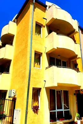 a yellow building with windows on the side of it at Къща за гости Вълчеви Несебър in Nesebar