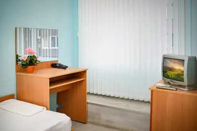 a room with a desk with a tv on a table at Family Hotel Varna in Varna City