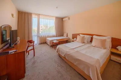a hotel room with a large bed and a television at Perla Plaza Hotel - All Inclusive in Primorsko