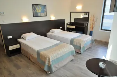 a hotel room with two beds and a piano at Hotel Burgas Free University in Burgas City