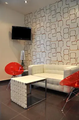 a living room with a white couch and red chairs at Hotel Burgas Free University in Burgas City