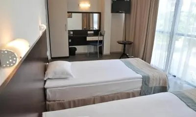 a hotel room with two beds and a desk at Hotel Burgas Free University in Burgas City