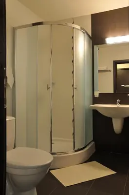 a bathroom with a shower and a toilet and a sink at Hotel Burgas Free University in Burgas City