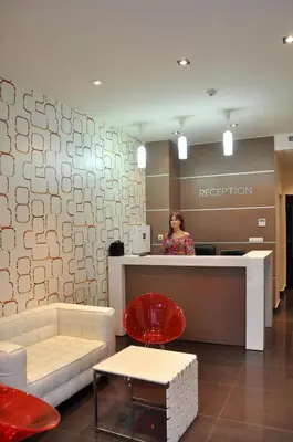 a woman standing at a reception desk in a lobby at Hotel Burgas Free University in Burgas City