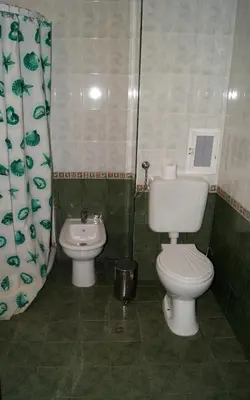 a bathroom with a toilet and a sink at Hotel Fors in Burgas City