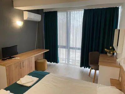 a hotel room with a bed and a desk and a window at Hotel Fors in Burgas City
