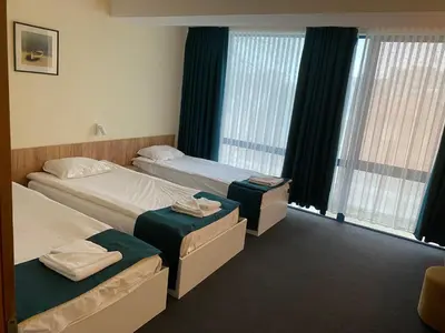 a hotel room with two beds and windows at Hotel Fors in Burgas City