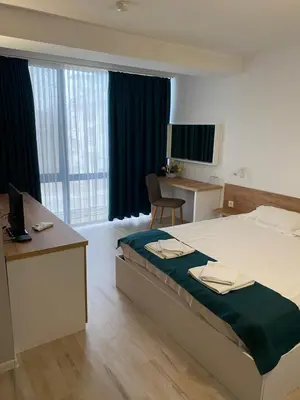 a bedroom with a bed and a desk with a computer at Hotel Fors in Burgas City