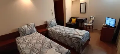 a hotel room with two beds and a tv at Matev Hotel in Burgas City