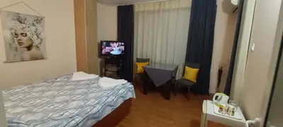 a hotel room with a bed and a television at Matev Hotel in Burgas City