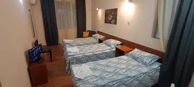 a room with two beds and a tv in it at Matev Hotel in Burgas City