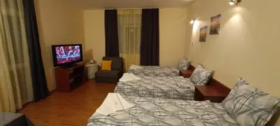 a hotel room with two beds and a flat screen tv at Matev Hotel in Burgas City