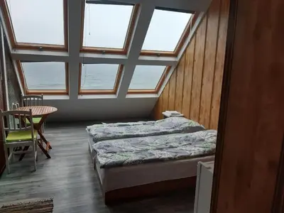 a room with two beds and a table and windows at Happy beach in Varna City