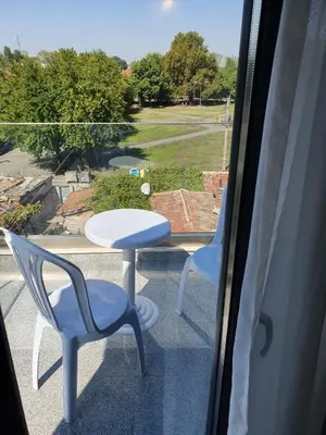 a table and two chairs on a balcony with a view at Family Hotel Novel City in Burgas City