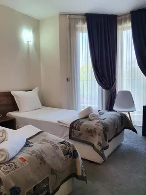 a hotel room with two beds and a window at Family Hotel Novel City in Burgas City